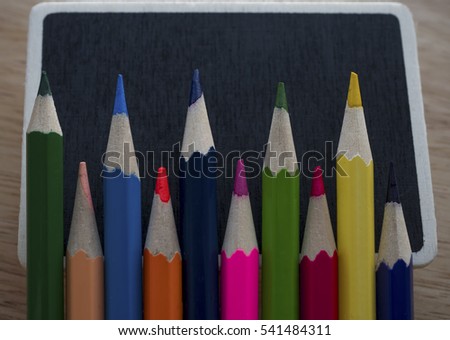 Colorful pencils over mini blackboard