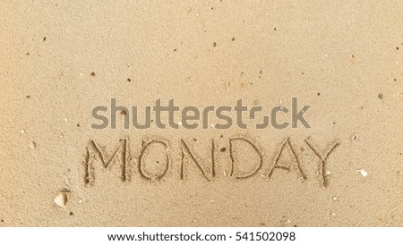 Handwriting words "MONDAY" on sand of beach