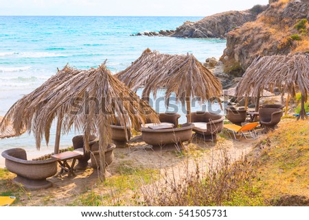 Summer greek beach vacation bakground with turquoise sea water and cafe under umbrellas, Greece