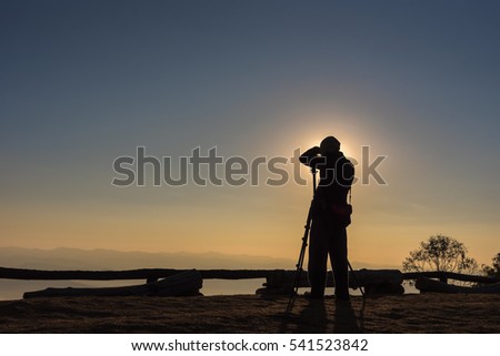 Silhouette of photographer taking photos in the mountains. Filter effect style
