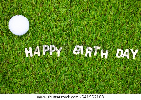 Golf ball and Happy Birthday lettering on green grass. Idea for golfer's birthday party invitation.