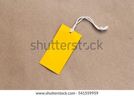Emtry yellow price tag on brown paper background 