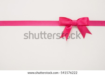 Decorative pink ribbon and bow on a white background