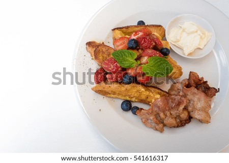 delicious croissant cooked in a french toast style with bacon and fruit