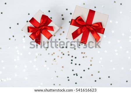 Two presents with red bow on white wooden rustic surface. Festive picture made in flat lay style with place for text.