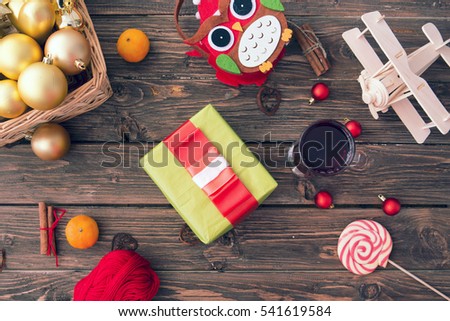 Christmas or New year concept. Gift box, christmas decorations and mulled wine with spices on old wooden table. Christmas set background. Toned picture.
