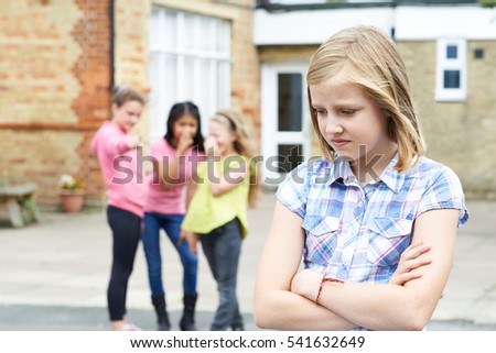 Unhappy Girl Being Gossiped About By School Friends Royalty-Free Stock Photo #541632649
