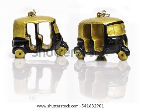 Tuk Tuks - Three wheelers - Gold and Black Two Miniature Models Isolated on Reflective White Surface Background