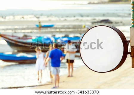 Mockup of beach restaurant round sign at asian seashore background.