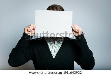 successful young businessman hiding behind a white banner, stylish, close-up manager