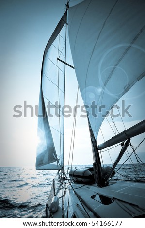 yacht sailing towards sunset - picture in blue tone