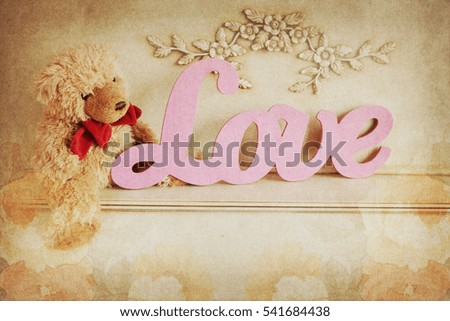 Valentine's day concept, letters "love" and flowers on old vintage wooden background