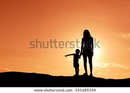 Silhouette mother and daughter at the sky sunset.