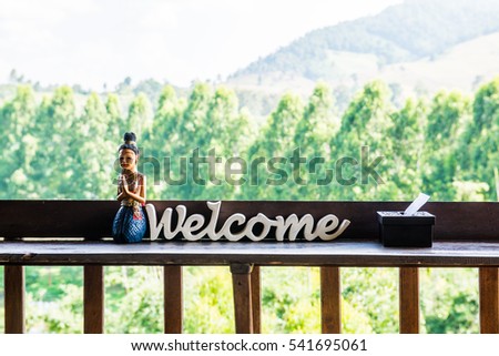 Thai Style Wooden Doll with Welcome Wooden Sign, Thailand.