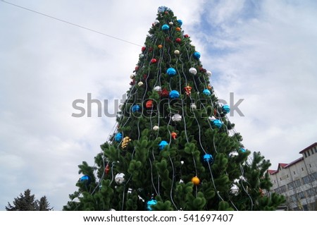 Christmas tree decorated with colorful Christmas balls on the background of the sky