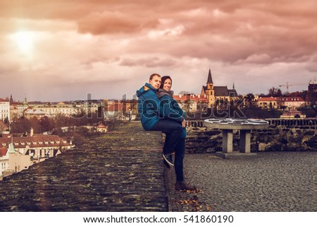 Pregnancy - happy pregnant couple walking in the park at the golden autumn time. couple is having fun in a city walk,Prague,Beautiful pregnant couple with big tummy is kissing,hugging