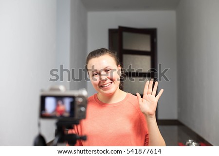Young female blogger recording a video for her subscribers by a professional camera