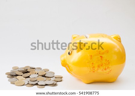 yellow piggy bank and coins isolated on white background
