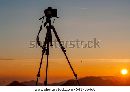 camera mounted on a tripod to photograph the sunset