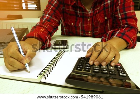 Man using calculator Calculate the cost of family and  bills with vintage toned,business concept background