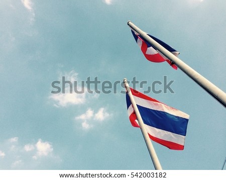 Thailand flag waving in the wind with beautiful blue sky and sunlight