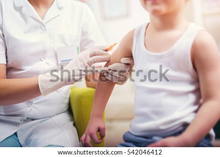 Pediatrician makes vaccination to small boy Royalty-Free Stock Photo #542046412