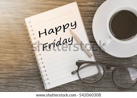 Concept Happy firday message on notebook with glasses, pencil and coffee cup on wooden table.