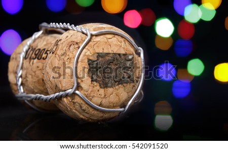 Champagne cork with the shape of Washington burnt in and colorful blurry lights in the background.(series)
