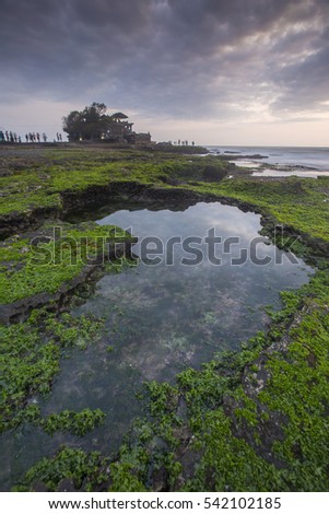Beautiful balinese landscape. Tanah lot on the rock against sunset sky. Bali Island, Indonesia. Low light and soft focus.