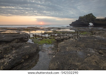 Beautiful balinese landscape. Tanah lot on the rock against sunset sky. Bali Island, Indonesia. Low light and soft focus.