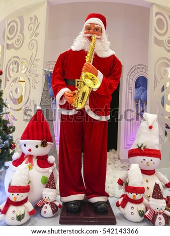 Santa Claus model playing saxophone with snowman