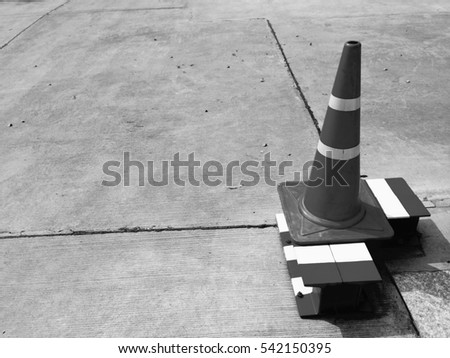 traffic cone, pylon, with white reflex sticker and orange stripes on concrete road, copy space