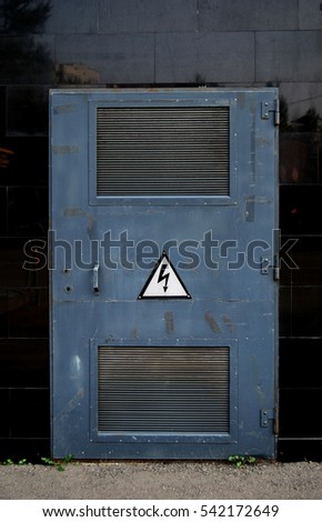 Texture of grey metal door with high voltage sign