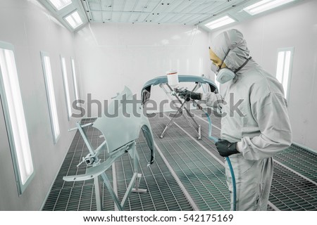 Worker painting a car parts in a paint booth, Royalty-Free Stock Photo #542175169