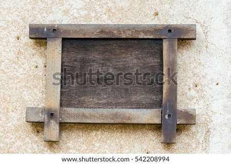 A blank wood board hanging on a dirty wall for background