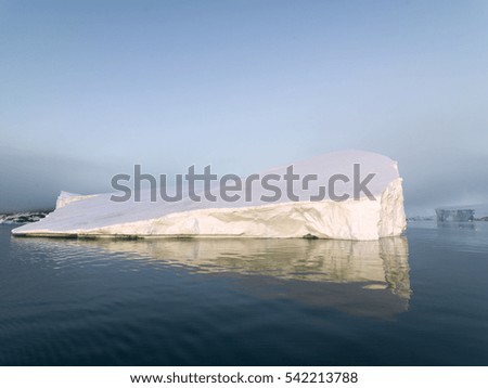 Arctic Icebergs Greenland in the arctic sea. You can easily see that iceberg is over the water surface, and below the water surface. Sometimes unbelievable that 90% of an iceberg is under water