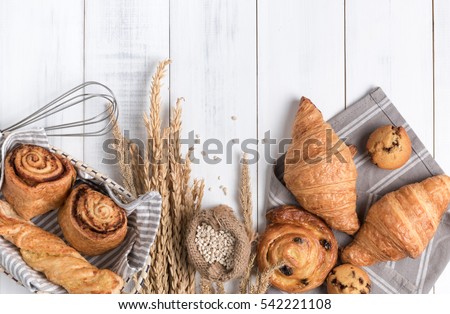 Homemade breads or bun on wood background, croissant puff cinnamon, breakfast food Royalty-Free Stock Photo #542221108