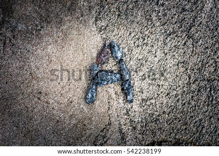 Latin letter "A" paved stones on the rock. View from above, image vignetting and highlighting the center