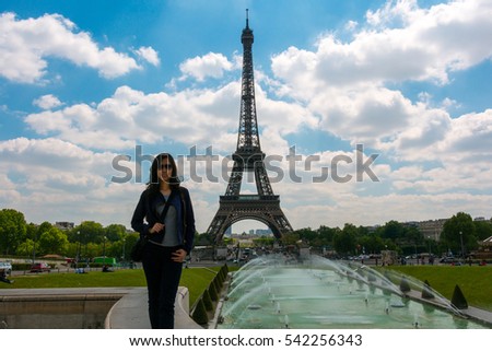 Beautiful Asian girl in Paris with Eiffel tower on background. Young Asian  girl outdoors near the Eiffel tower. Girl in Paris on a sunny spring. Asian girl in Europe. Travel and Lifestyle