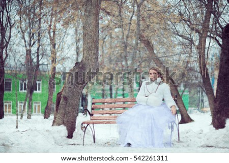 Girl, Blonde in a white fur coat with a clutch on a Park bench. Winter photo session in retro style stylized picture