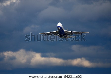 Civil wide-body passenger airplane taking off in front of dark clouds.