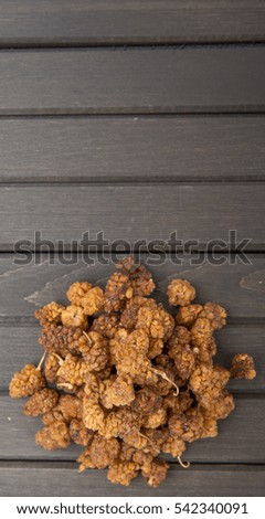 Dried mulberry over wooden background