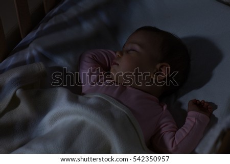 Adorable baby sleeping at night. Little girl in pajama taking a nap in dark room / Baby Sleeping on the bed