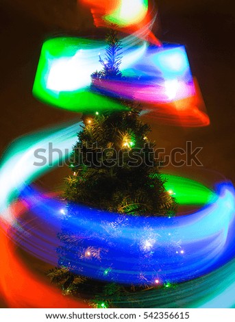 a Christmas tree and flying multicolored lights in a long exposure