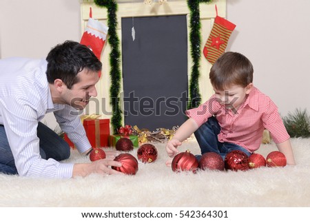 Father and son play with Christmas decorations on New Year