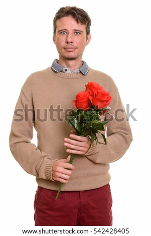 Handsome Caucasian man holding red roses ready for Valentine's day isolated against white background