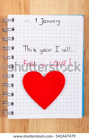 New year resolution fall in love written in notebook, red wooden heart, symbol of love