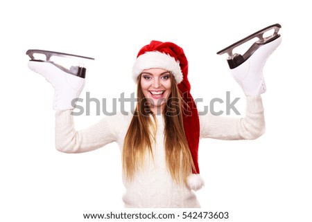 Winter sport activity. Young woman with ice skates getting ready for ice skating,. Smiling cheerful girl wearing santa claus hat on white