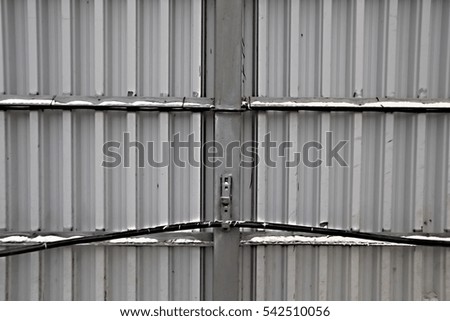 Corrugated iron fence with a black high-voltage cable