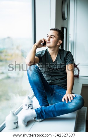 Young man use phone  on panoramic window